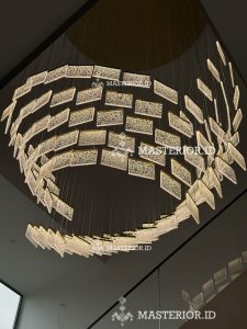 Contemporary circular chandelier with layered illuminated glass panels and brushed brass finish.