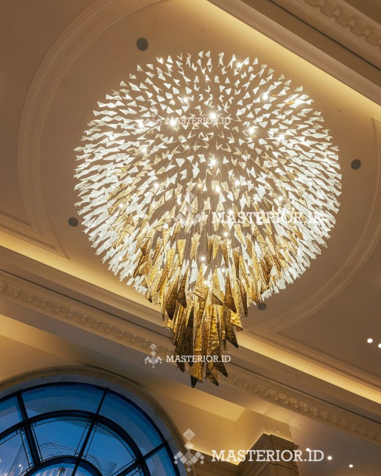 Grand spherical crystal chandelier creating a dramatic focal point in a luxury hotel lobby.