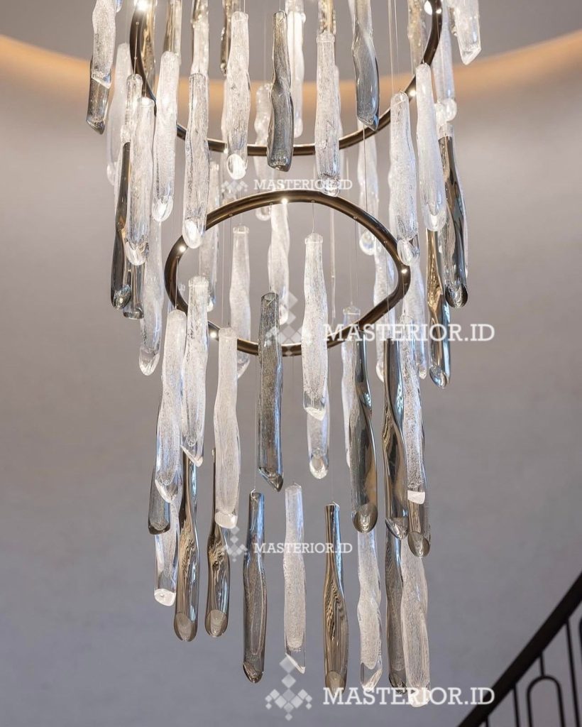 White fringe spiral chandelier in modern living room — custom lighting Jakarta. Modern cascading crystal chandelier with suspended hand-blown glass elements and brushed brass accents.